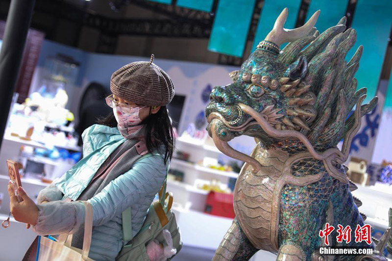 Суретте Далянь көрме алаңындағы көрермен «Кирин» үш өлшемді қабық мүсінімен суретке түсіп жатыр